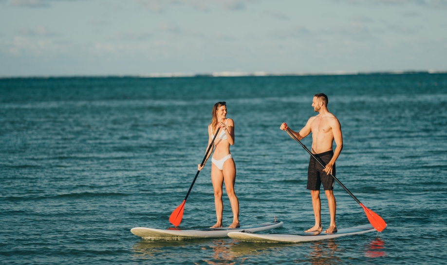 Adventurous couple enjoying paddleboarding together at Veranda Resorts in Mauritius