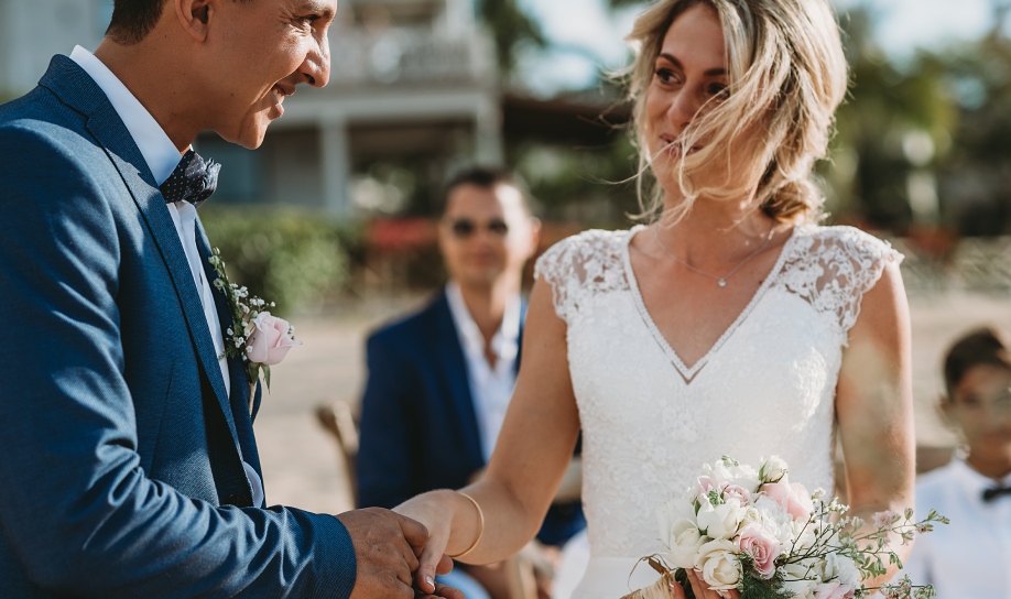 A young couple saying yes at Veranda Pointe aux Biches, Mauritius, surrounded by their family and friends