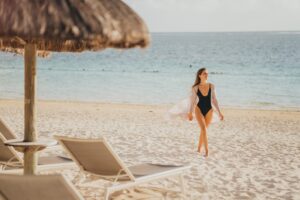 Une femme marchant sur la plage pendant son séjour dans un hôtel à l’île Maurice